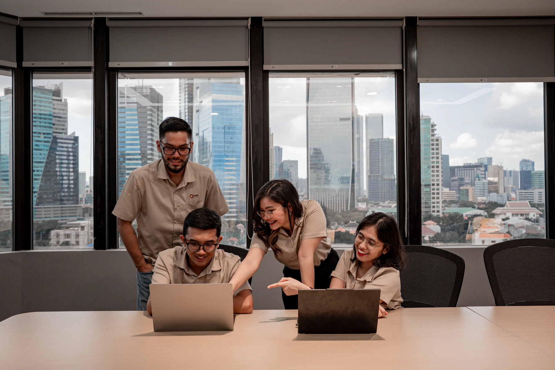 A team collaborating around laptops in a meeting room